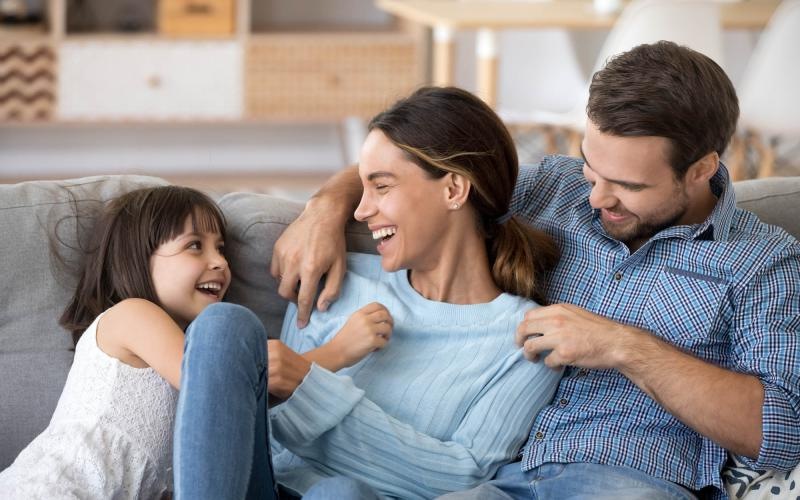 a man and woman sitting on a couch with a child